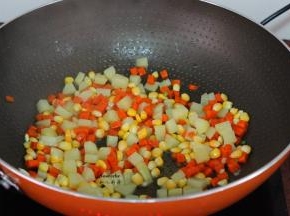 土豆下锅翻炒片刻，放入胡萝卜、玉米下锅爆炒八成熟熟；