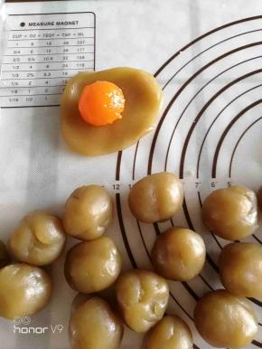 将蛋黄包入莲蓉中，揉成圆形。
