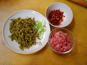 猪肉洗净剁碎，放油、盐、酱油拌均，酸豆角洗净切碎，干辣椒切碎；
