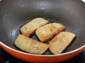 热锅，倒入花生油，放入切好的豆腐小火煎至微黄，翻转另外煎至金黄