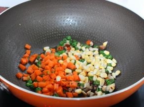 加入胡萝卜、玉米粒继续翻炒；