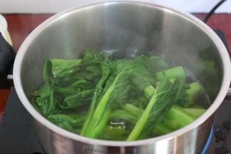 清水煮沸，放入生姜，汆烫菜心，捞出菜心放入盆中