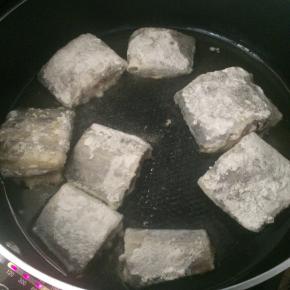 腌制好的带鱼段裹一层干淀粉。
平底锅内倒入适量食用油，放入带鱼段，小火煎制。