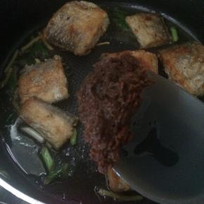 放入一大勺豆瓣酱。加入1小碗水，大火烧开，小火慢炖10分钟。