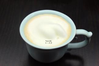 把奶泡倒入巧克力酱咖啡杯中；