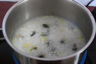 熬好的粥，放入皮蛋粒、生姜丝、葱白，熬煮5分钟；
