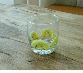 把奇异果片贴入杯中。