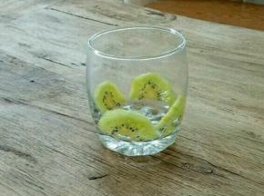 把奇异果片贴入杯中。