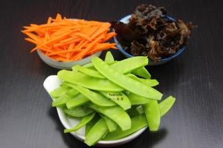 泡发的木耳洗净去头；荷兰豆去豆荚、洗净；胡萝卜去皮洗净切丝；