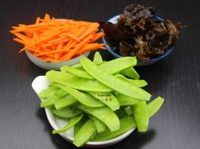 泡发的木耳洗净去头；荷兰豆去豆荚、洗净；胡萝卜去皮洗净切丝；