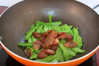 加入腊肠一起翻炒；