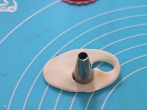 用最小号的裱花嘴背面切割出白色的胡子部分，在黄色翻糖上切割出耳朵。