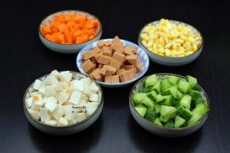 所有食材洗净，玉米掰成粒，杏鲍菇、火腿、胡萝卜、青瓜切成玉米大小粒；