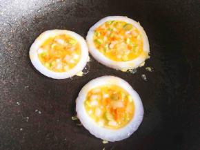 用勺子将蛋液倒入洋葱圈里，盖上锅盖小火煎熟