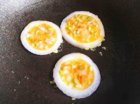 用勺子将蛋液倒入洋葱圈里，盖上锅盖小火煎熟