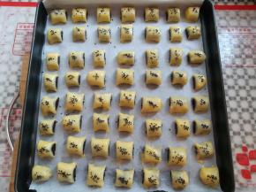 所有的枣泥酥放入垫了油纸的烤盘里，刷上一层薄薄的蛋液，撒上适量的芝麻