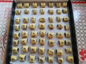 所有的枣泥酥放入垫了油纸的烤盘里，刷上一层薄薄的蛋液，撒上适量的芝麻