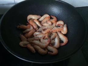 锅中热油，多一些半煎半炸虾，直到变色弯曲捞出备用