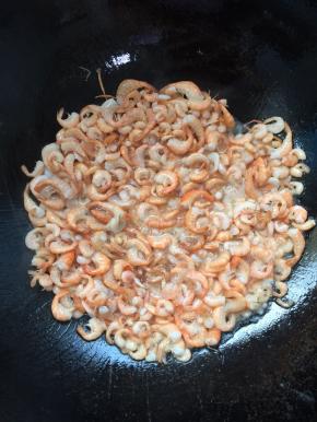 锅烧热倒入适量的油，放入腌制好的小河虾，慢慢的煸炒！