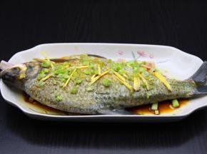 肚内摸上盐、酱油、塞入葱白、生姜丝、香菜根。再淋上油、酱油、盐、料酒、芝麻油、腌制10分钟；