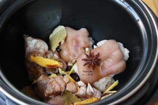 捞出猪蹄沥干水，放入压力锅，加入料酒、生姜、八角、香叶、鸡粉，小半碗水；