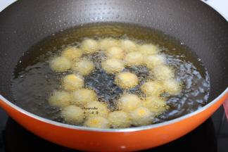 把南瓜小球放入油锅，中途可以翻转；