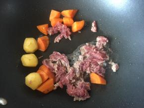 待胡萝卜和小土豆炒至表面微黄后放入牛肉炒