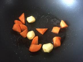 锅里热油后放入切块的胡萝卜和去皮的小土豆