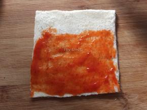 将吐司片2/3面积涂抹上蕃茄酱