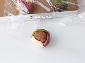 5 把桃山皮按压成中间厚，四周薄的饼皮，放入内陷