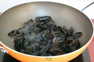 煎过五花肉的油锅，放入木耳爆炒；