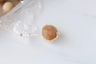 10把面皮按压成中间厚，四周薄的饼皮，放入莲蓉馅