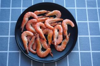 将虾煮熟捞起沥干水，剪去虾尾虾须，备用。