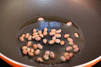 热锅，倒油放入花生米炸熟，放凉去皮；