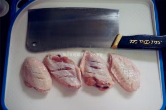 把鸡翅捞出，擦干水分，在正反面各划3刀。