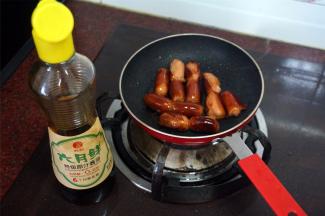 煎锅下油，放入脆皮肠，煎至爆皮后淋入少许生抽酱油，炒均，装起备用。