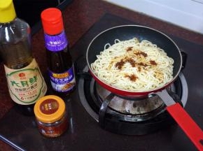 将煮好的面条倒入煎锅，小火加热，同时加入适量的酱油，XO酱，芝麻油，炒均匀。