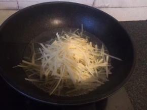 烧开一锅水，放入土豆丝焯烫一下，捞出沥干备用