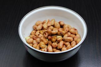 把炒的花生米用盘子装好，趁热倒入拌均好的白砂糖陈醋；