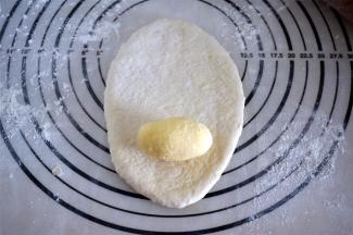 取一份面团，擀成椭圆形，馅料放在椭圆面片的长轴上（我图所示放置的位置不对）。