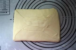 水油皮完全包裹住油酥皮，封口捏紧。自两端分别向三分之一处内折。