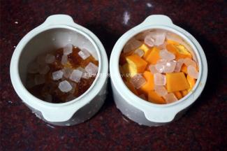 洗净的桃胶平均分到两个小炖盅里，往其中一份放入木瓜块，分别放入30克冰糖。