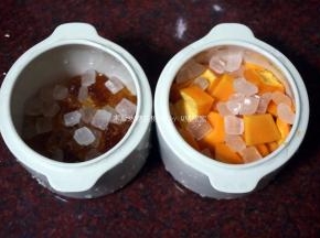 洗净的桃胶平均分到两个小炖盅里，往其中一份放入木瓜块，分别放入30克冰糖。