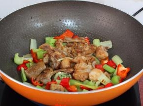 把炸好兔肉、鸡粉加入锅中；