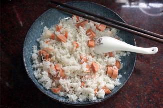 盘子抹上少许油，倒入米饭、火腿蟹柳丁，拌均匀。放入微波炉，盖上专用盖，高火加热3分钟，取出。