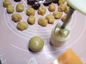 开口一边向下放置在烤盘里，用模具压出花纹。怕沾的可以把团好的球在淀粉里滚一圈再用模具压。