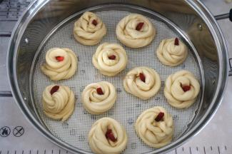 将面条旋转卷起，收口放在最上面，用枸杞装饰，放在垫了硅胶垫的蒸笼中。