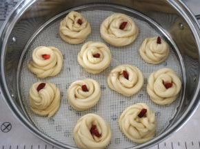 将面条旋转卷起，收口放在最上面，用枸杞装饰，放在垫了硅胶垫的蒸笼中。