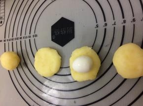 将土豆泥揉成圆形，在 用手按扁， 将鹌鹑蛋放入中间，然后将鹌鹑蛋包在里面