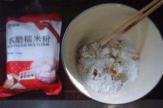 取红薯泥180克，加入100克水磨糯米粉，15克细砂糖，揉合。若感觉太干，可以适量加点清水，这里添加了12克清水。